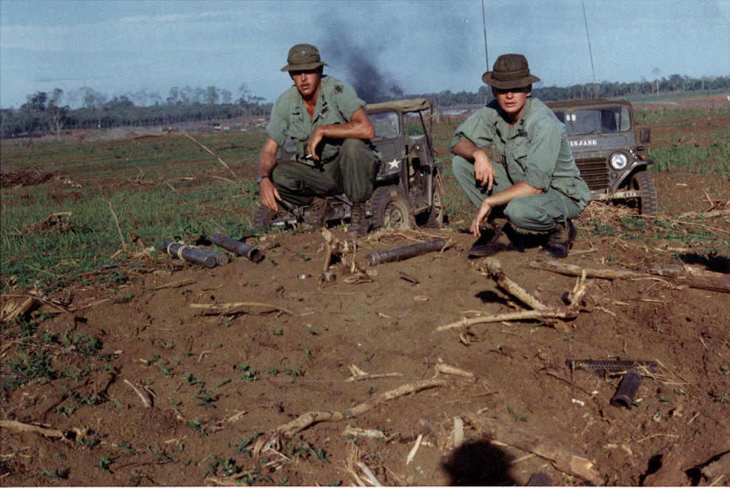 Two Soldiers with the 131st Engineer Company, Vermont National Guard, inspect North Vietnamese artillery shells after an attack. Photo by retired Sgt. 1st Class Ross Andrews, used with permission.